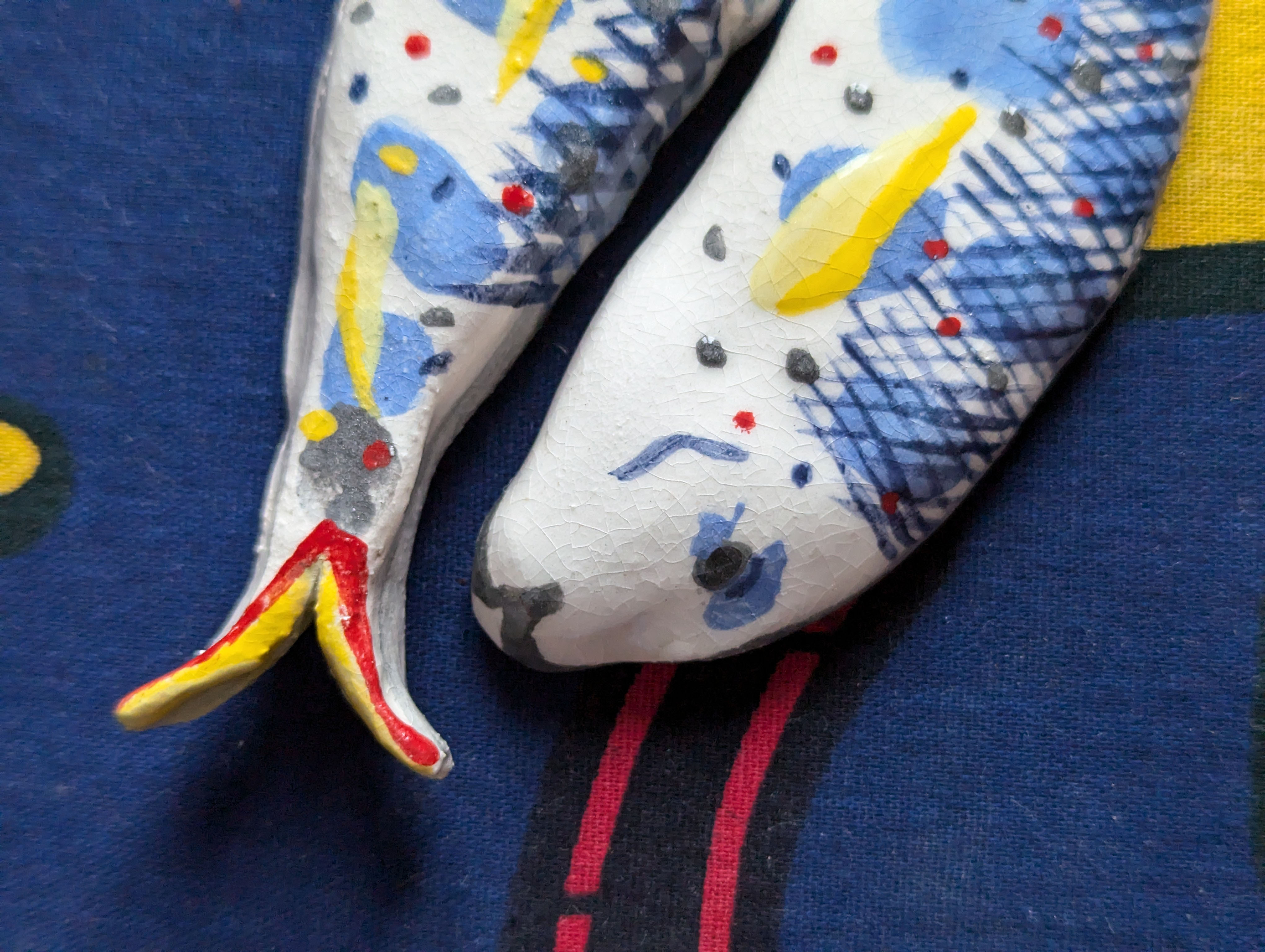 détail de 2 sardines multicolores en faïence